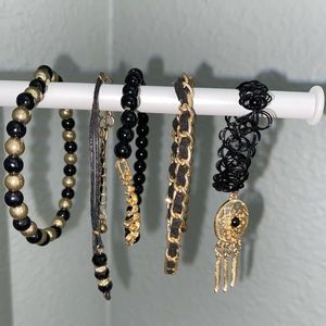 set of five black and gold bracelets and anklets